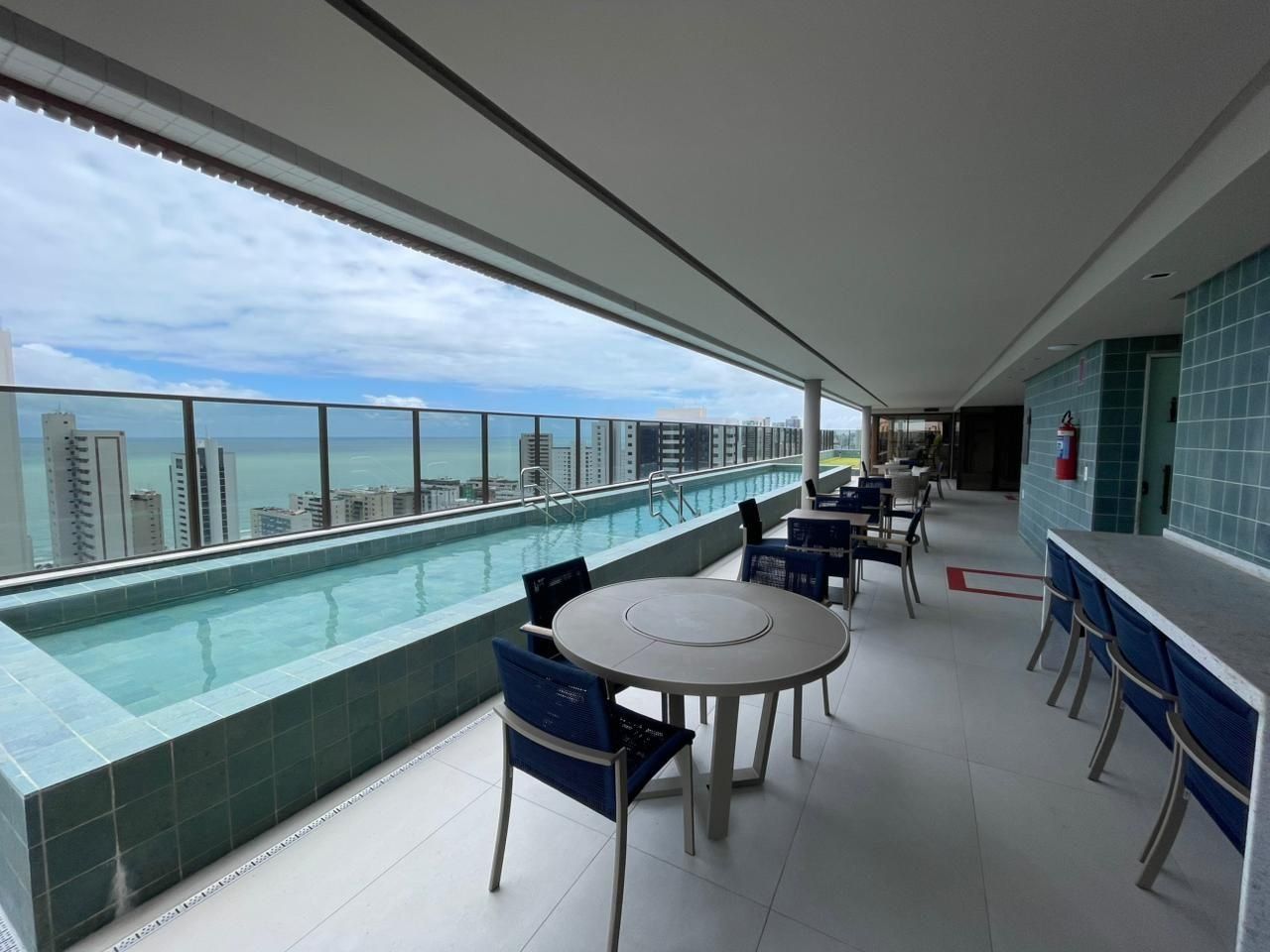 Un bar en la azotea con piscina, asientos y vistas del horizonte de la ciudad.