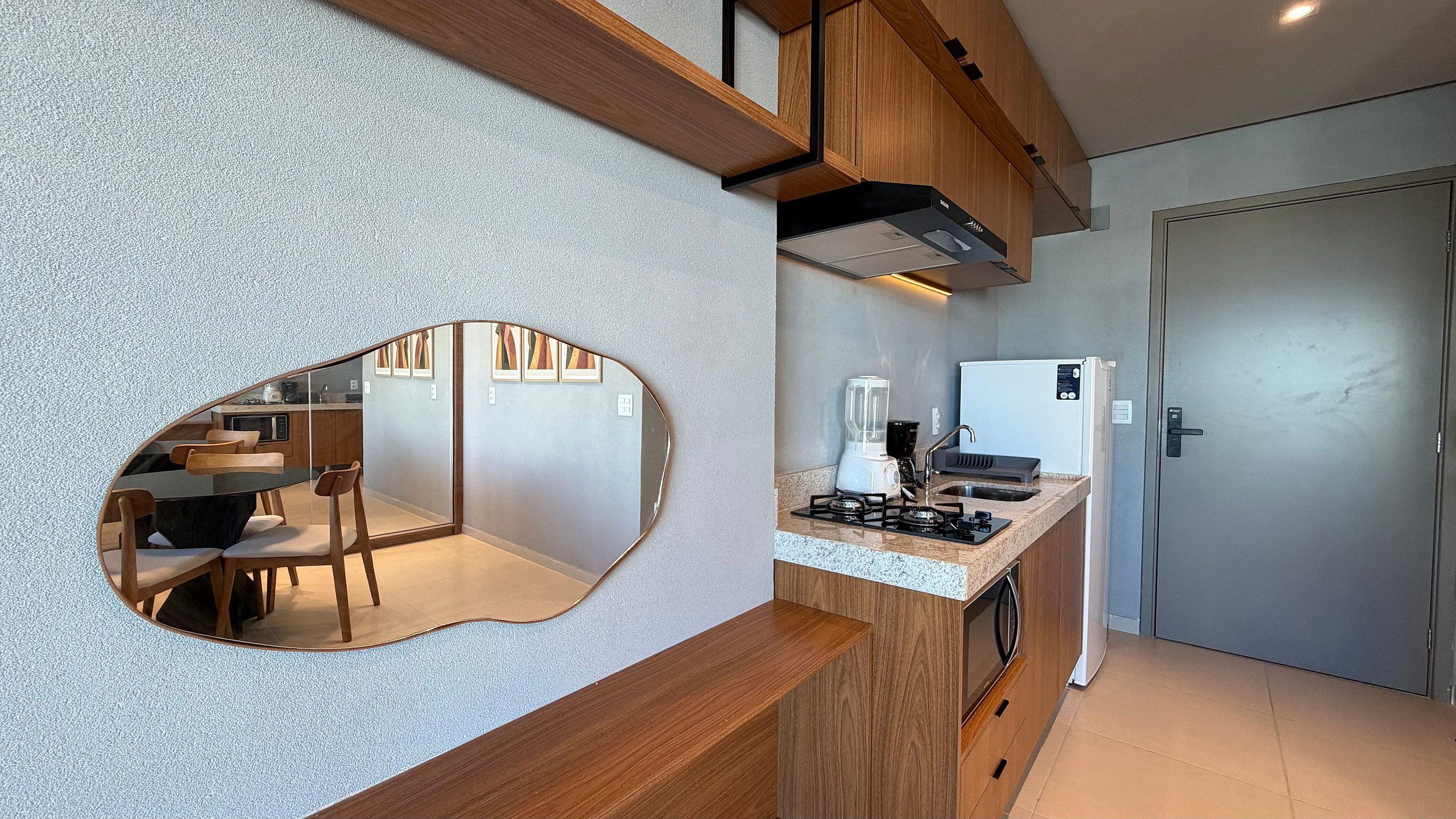 A modern kitchen with a built-in island, wooden cabinets, and a large mirror.