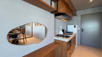 A modern kitchen with a built-in island, wooden cabinets, and a large mirror.