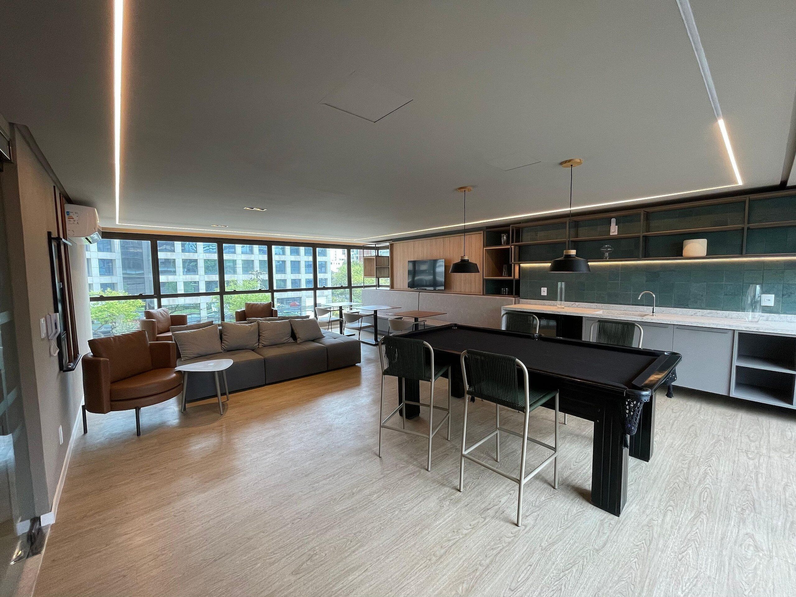 Una cocina moderna con zona de comedor, ventanas amplias y horno empotrado.