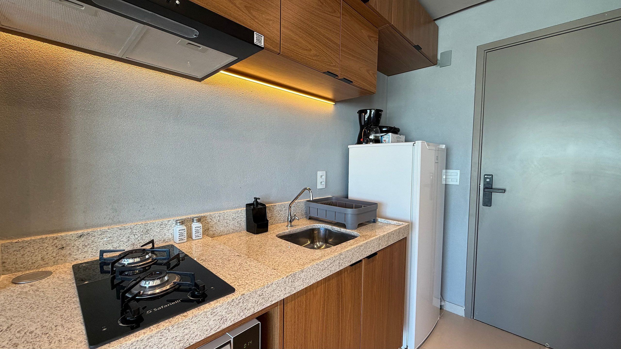 A compact kitchen with a gas stove, a sink, and a refrigerator.