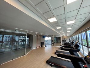 A gym with treadmills, exercise balls, and a glass wall. - Icon Design Living por YOLO (Recife)