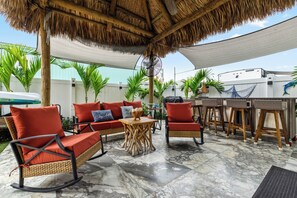 A covered outdoor seating area with wicker furniture, a table, and a fan. - Lovely 1-bedroom Tiny home with Central AC in enchanting Key Largo (Key largo)