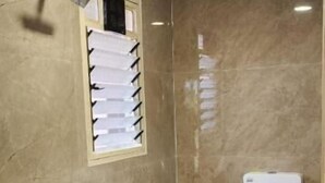 A bathroom with a sink, toilet, shower, and a small step leading to the shower. - Saavi Resort Shrivardhan (Shrivardhan)