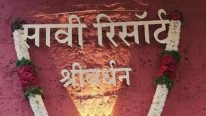 A wall with a garland and text in a foreign language. - Saavi Resort Shrivardhan (Shrivardhan)