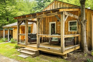 Eine Holzhütte mit Veranda, einem Geschäftsschild und Sitzgelegenheiten im Freien.