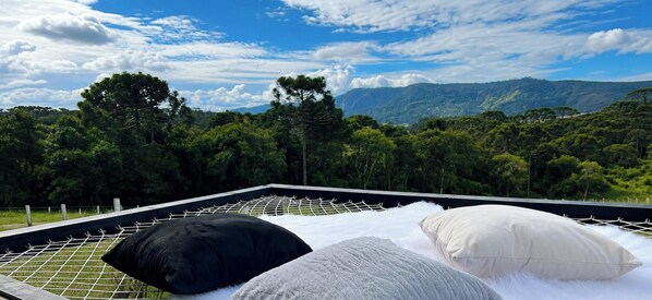 Una cama con vistas a un paisaje montañoso.