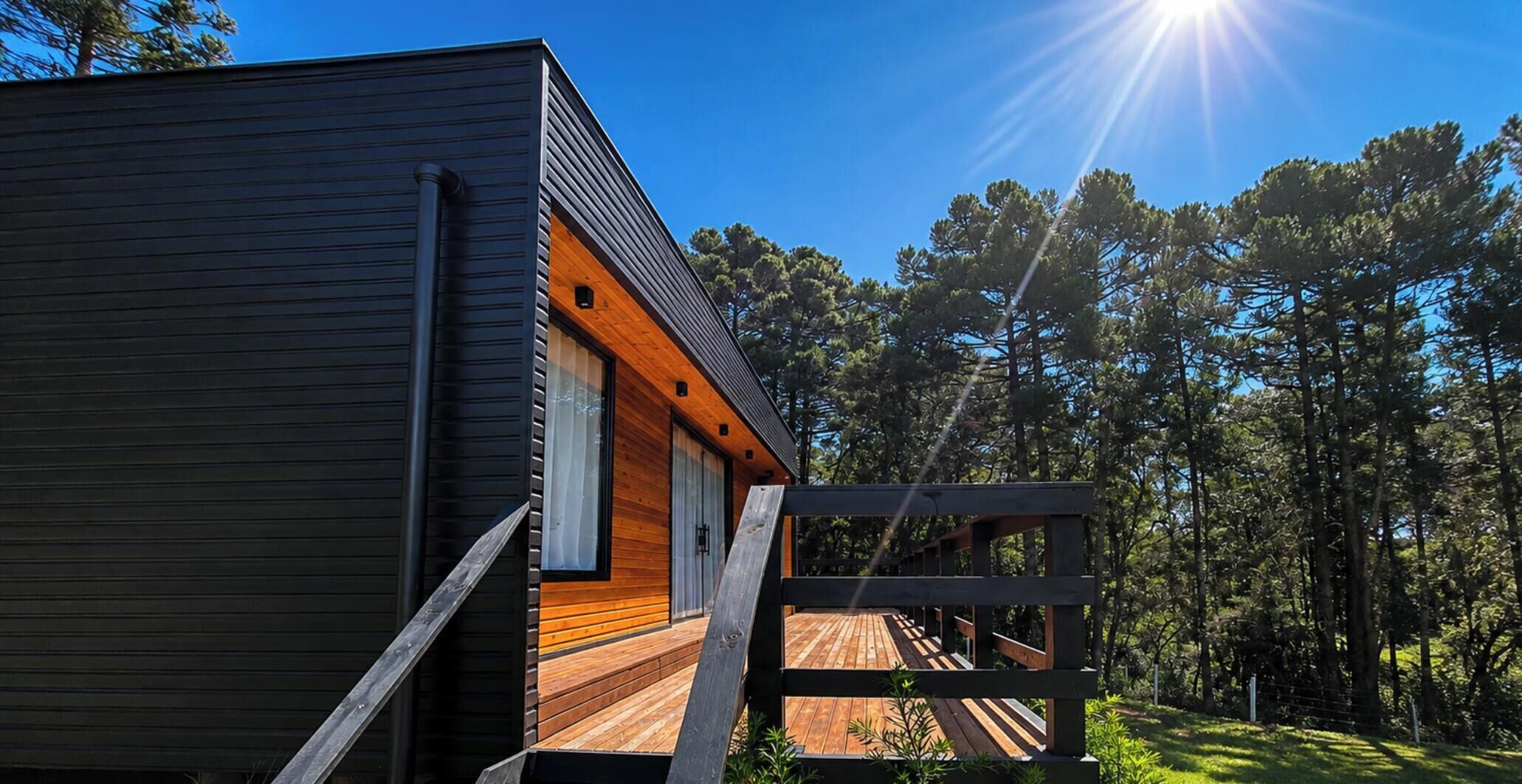 A modern cabin with a wooden deck and a garage.