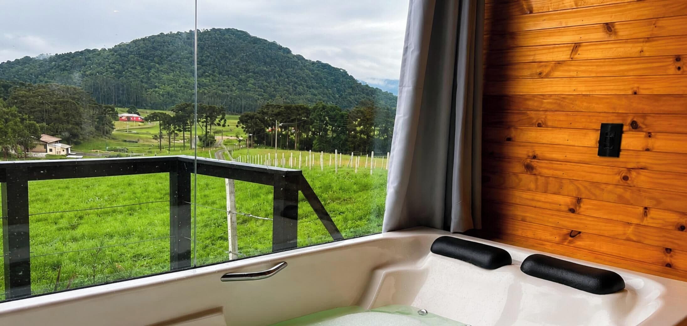 A room with a view of a green landscape and a wooden wall.