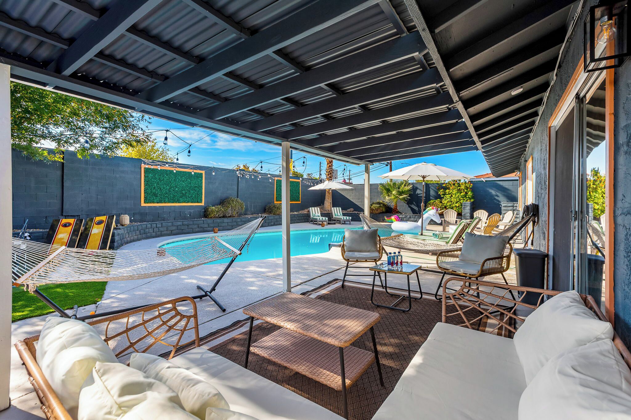 Eine Außenpatio mit Pool, Liegestühlen und einer überdachten Sitzgelegenheit.