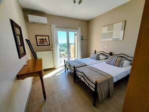 A bedroom with a bed, a desk, and a view through a glass door. - Villa Dalmatia • Luxury Calm with Beautiful Sea & Mountain Views (Argostoli)