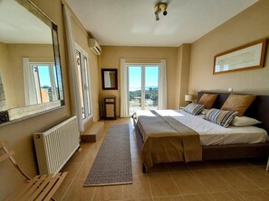 Ein Schlafzimmer mit einem großen Bett, einem Heizkörper, einem Fenster und einem Balkon.