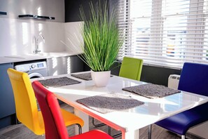Una cocina moderna con encimera blanca, un lavamanos y una planta en maceta.