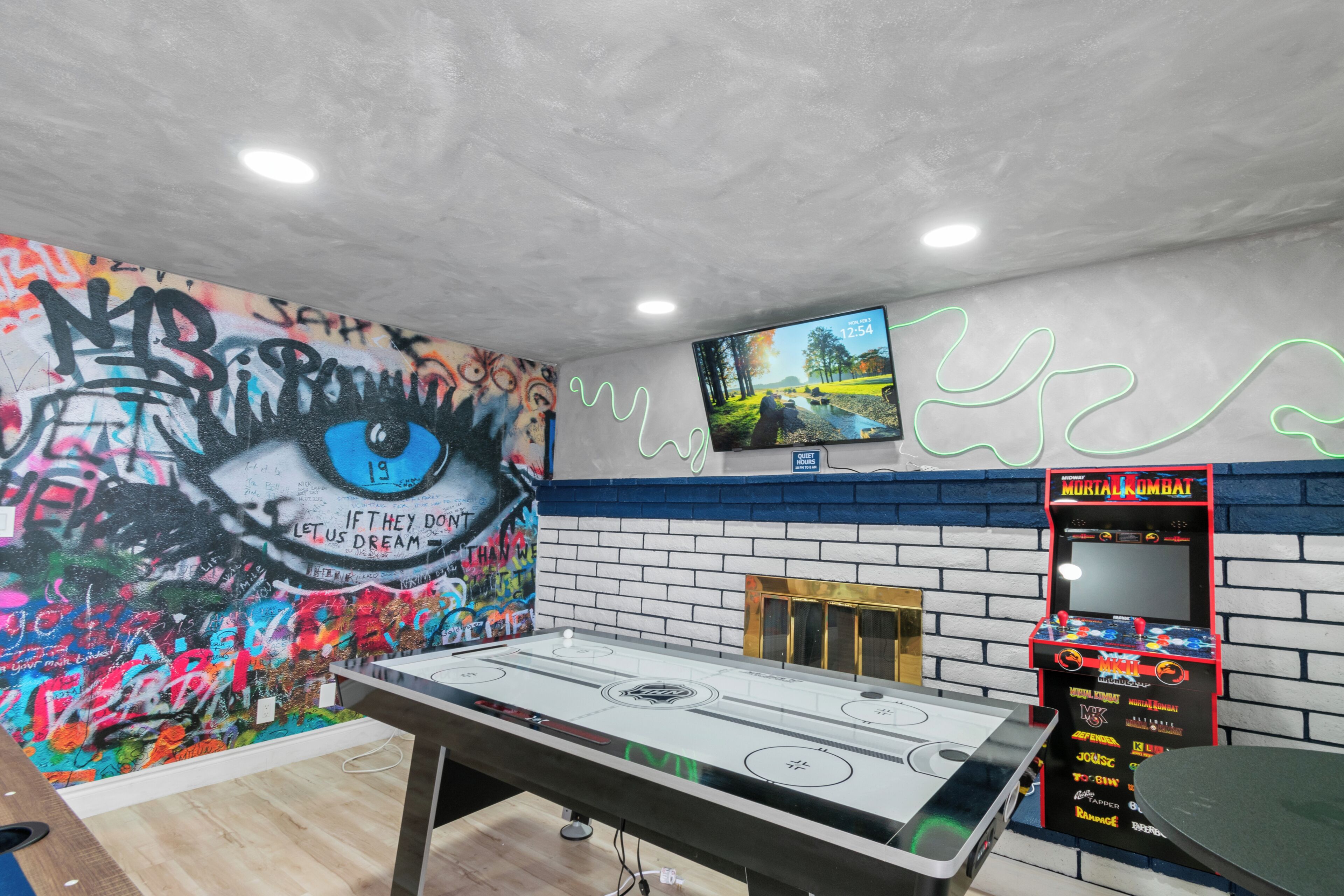 Ein Zimmer mit Tischfußball, Fernseher an der Wand und Graffiti-Kunst.