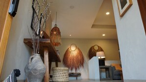 A modern interior with a wooden bench, a woven basket, and a hanging light fixture. - Luxury penthouse with a private terrace and ocean views | Ayuuk (Cruz de Huanacaxtle)