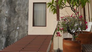A balcony with a wooden pergola, potted plants, and a view of a residential area with palm trees. - Luxury penthouse with a private terrace and ocean views | Ayuuk (Cruz de Huanacaxtle)