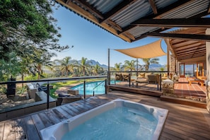 A pool area with a hot tub, outdoor seating, and a view of a mountain range. - the MANOR house by Kana Guest Farm (Stellenbosch)
