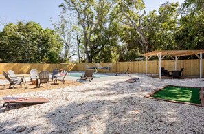 A backyard with a pool, outdoor seating, and a covered patio area. - Earthy Oasis: Private Pool, Putt Putt & Fire Pit (Largo)