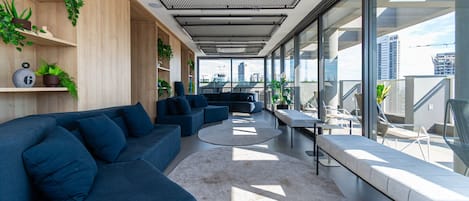A modern lounge area with a sofa, chairs, and a small table.