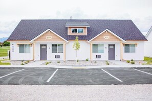 A two-story building with a grey roof and a central entrance.