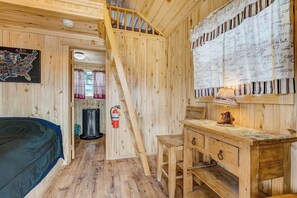 Ein Holzblock-Interieur mit Treppe, einer Karte an der Wand, einem Schreibtisch und einem Feuerlöscher.