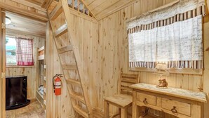 A wooden interior with a staircase, a small desk, a fire extinguisher, and a window with a curtain. - Our Cabin is great for youth groups, reunions and families! (Buena Vista)