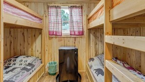 A cabin with bunk beds, a window with curtains, and a small refrigerator. - Our Cabin is great for youth groups, reunions and families! (Buena Vista)