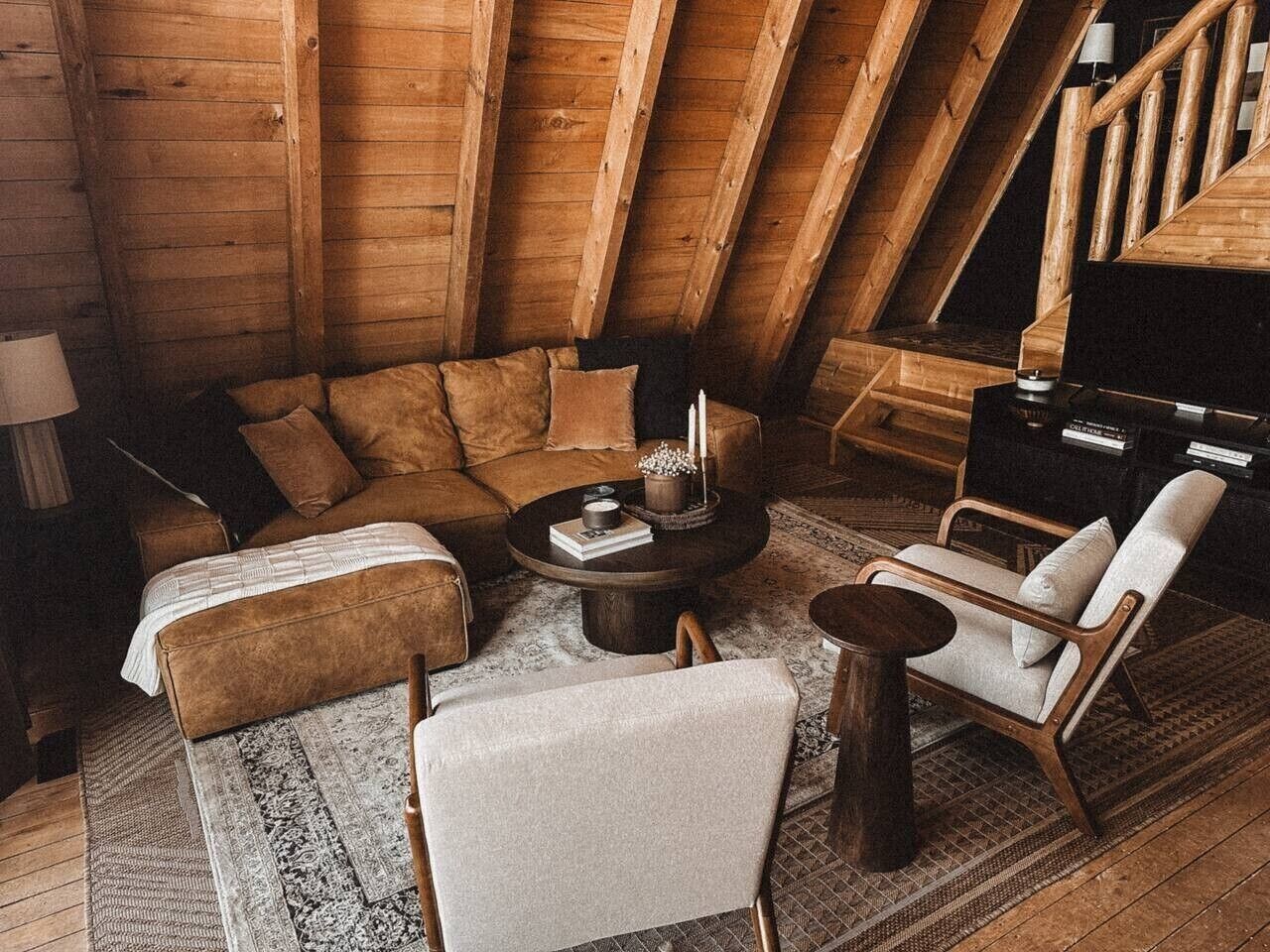 Een knus loft-appartement met houten plafond, een zithoek, een salontafel en een stoel.