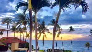 A pool area with palm trees and a view of the ocean at sunset. - Beachfront 4BR, 2 Condos for 12 in Kihei, Maui! (Kihei)