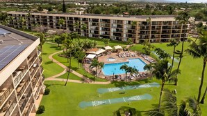 A hotel with a swimming pool, tennis courts, and a view of mountains. - Beachfront 4BR, 2 Condos for 12 in Kihei, Maui! (Kihei)
