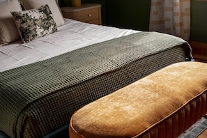 A neatly made bed with a patterned bedspread and a matching bench. - Stylish & Modern Cabin: Hot Tub, Sauna, Pickleball (Berkeley Springs)
