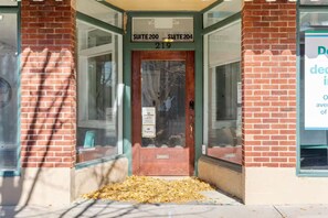 A building entrance with a sign indicating 'SUITE 200' and 'SUITE 204' above the door. - C-Street Art Loft (Springfield)