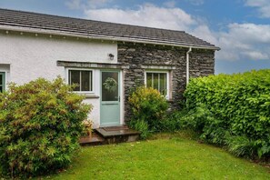 A two-story house with a stone facade and a green door. - No.6 Brantfell House (Bowness-on-Windermere)