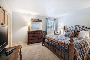 A bedroom with a bed, dresser, mirror, and a television. - It's Four O'Clock Somewhere (Breckenridge)