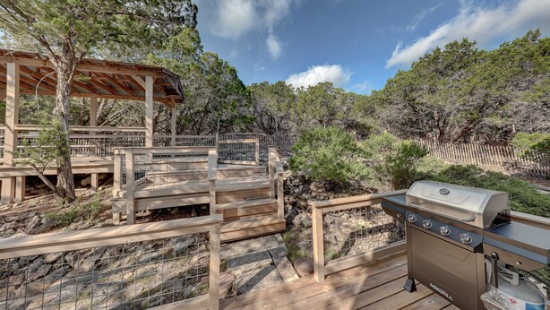 Eine Terrasse im Freien mit Grill und Holzboden.