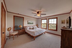 A bedroom with a bed, a desk, a chair, a ceiling fan, and two windows. - River Access +EV + WI-FI+ Pets+ King+ Firepit (Hunt)