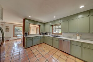 A kitchen with green cabinets, a microwave, and a dishwasher. - River Access +EV + WI-FI+ Pets+ King+ Firepit (Hunt)