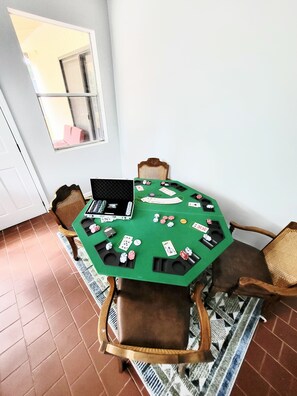 Een groene poker tafel bekleed met vilt, met kaarten en fiches, omringd door houten stoelen.