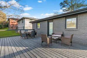 A deck with outdoor furniture, a brick building, and a clear sky. - Family-Friendly 4BR Home | Near Downtown ATL (Atlanta)
