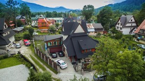A residential area with houses, cars, and a mountainous backdrop. - Fantastic 9-bedroom house in Zakopane for your perfect getaway (Zakopane)