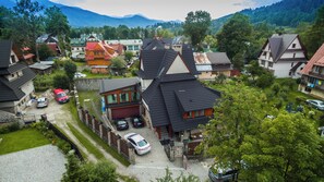 Ein Wohngebiet mit Häusern, Autos und einer bergigen Landschaft im Hintergrund.