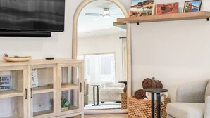Een moderne woonkamer met een flatscreen televisie, een bank, een salontafel en een open haard.