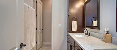 A bathroom with two sinks, a mirror, and a towel rack.