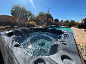 A hot tub with a clear view of the water, surrounded by a patio area with a pergola and a pool. - Sleeps 12 w/ ping pong & pool table| comfort + (Lake Havasu City)