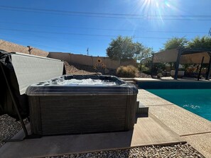 A hot tub outdoors with a pool in the background. - Sleeps 12 w/ ping pong & pool table| comfort + (Lake Havasu City)