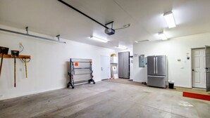 Tilava sisätila, jossa on suuri avoin pohjaratkaisu, kattoon asennettu projektori ja jääkaappi seinää vasten.