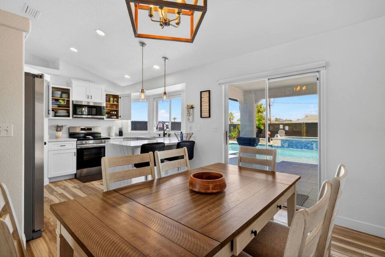 Una cocina moderna con comedor, una isla grande y vistas a una piscina.