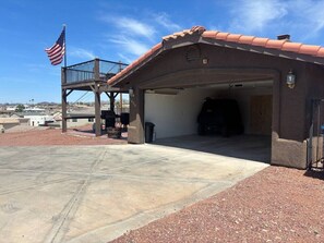 Een gebouw met een garage-ingang, een vlaggenmast met de Amerikaanse vlag en een terras.
