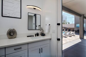 A modern bathroom with a large mirror, a sink, and a decorative vase. - Resort-Style Entertainer | Near Launches (Lake Havasu City)
