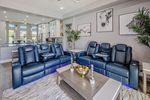 A modern living room with a large L-shaped sofa, a coffee table, and artwork on the walls. - Resort-Style Entertainer | Near Launches (Lake Havasu City)